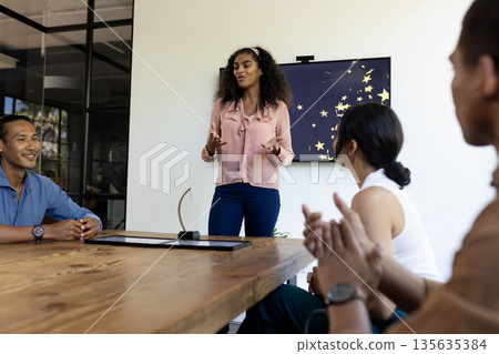 African American woman presenting in modern office meeting with diverse colleagues 135635384
