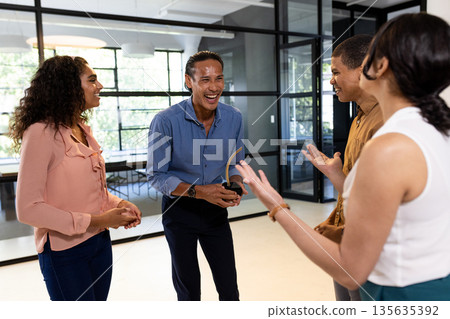 Business team in office laughing and discussing ideas during casual meeting Business team in office laughing and discussing ideas during casual meeting 135635392