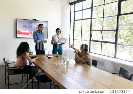 Business team in office presenting award during meeting, smiling and applauding 135635394