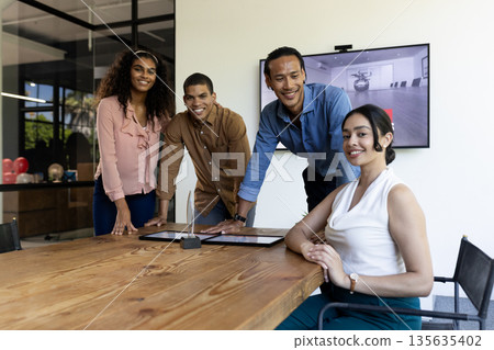 Diverse business team collaborating around conference table in modern office 135635402