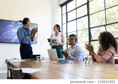 Business team applauding colleague during presentation in modern conference room Business team applauding colleague during presentation in modern conference room 135635405