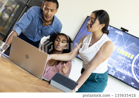Business team collaborating on laptop in modern office, discussing project details Business team collaborating on laptop in modern office, discussing project details 135635418