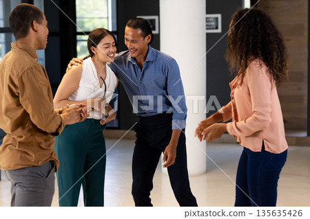 Colleagues laughing and bonding during casual team-building session at office Colleagues laughing and bonding during casual team-building session at office 135635426