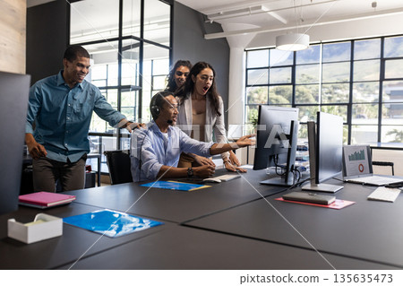 Diverse business team collaborating and discussing project at modern office desk 135635473