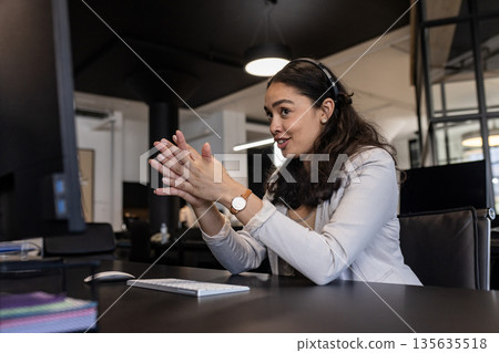Businesswoman in office using headset, engaging in video conference call Businesswoman in office using headset, engaging in video conference call 135635518