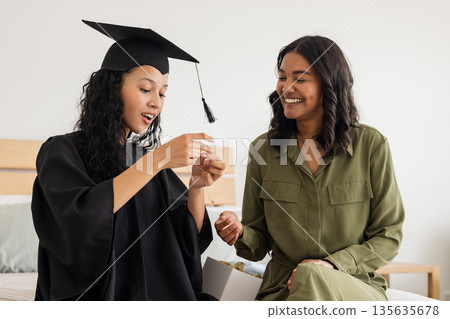 Graduation day, African American mother and daughter celebrating with joyful smiles 135635678