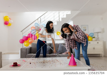 Cleaning party decorations and confetti, African American women smiling in living room Cleaning party decorations and confetti, African American women smiling in living room 135635704