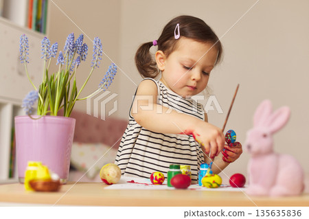 Little child girl paint Easter eggs at home. kid is preparing for Easter. Little child girl paint Easter eggs at home. kid is preparing for Easter. 135635836