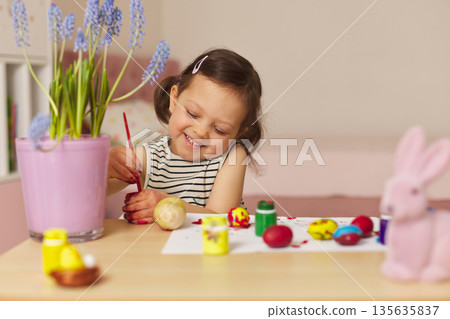 Little child girl paint Easter eggs at home. kid is preparing for Easter. Little child girl paint Easter eggs at home. kid is preparing for Easter. 135635837