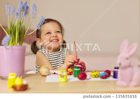 Little child girl paint Easter eggs at home. kid is preparing for Easter. Little child girl paint Easter eggs at home. kid is preparing for Easter. 135635838