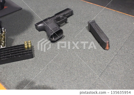 A pistol and a clip on the table. The concept of preparing a murder. A pistol and a clip on the table. The concept of preparing a murder. 135635954