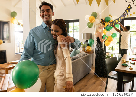 Decorating with balloons and banners, friends celebrating birthday joyfully at home 135636037