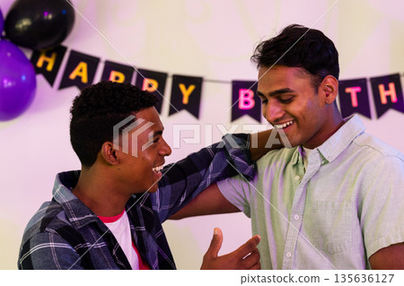 Celebrating birthday, friends smiling and talking with festive decorations around them 135636127