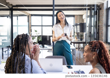 Leading meeting, businesswoman with colleagues discussing ideas in modern office setting 135636146