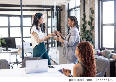 Exchanging gifts in modern office, colleagues celebrating successful business achievement Exchanging gifts in modern office, colleagues celebrating successful business achievement 135636180