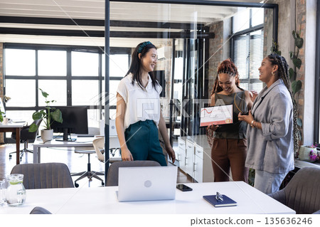 In office, diverse businesswomen sharing award and celebrating success together 135636246
