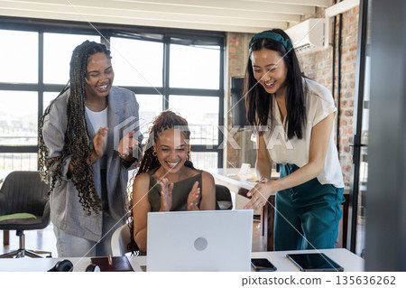 Celebrating success, diverse businesswomen clapping and smiling at laptop in office 135636262