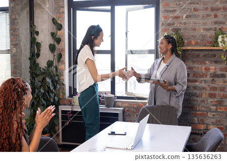 Shaking hands, colleagues in office celebrating successful business partnership Shaking hands, colleagues in office celebrating successful business partnership 135636263