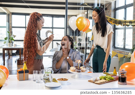 Celebrating birthday in office, colleagues sharing cupcakes and balloons, enjoying moments 135636285