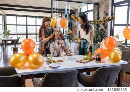 Celebrating birthday, colleagues sharing cake and joyful moments with balloons at office 135636295