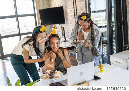 Celebrating birthday with cupcakes and party hats, colleagues feeling joyful in office Celebrating birthday with cupcakes and party hats, colleagues feeling joyful in office 135636330