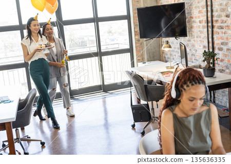 Colleagues bringing cupcakes and balloons to office celebration, smiling and joyful Colleagues bringing cupcakes and balloons to office celebration, smiling and joyful 135636335