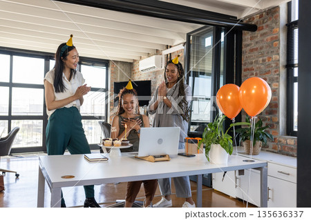 Celebrating success, diverse colleagues clapping and smiling with cupcakes in office 135636337