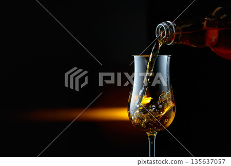 Bourbon being poured into a glass. 135637057