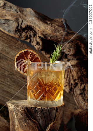 An old-fashioned cocktail over ice on an old wooden stump. An old-fashioned cocktail over ice on an old wooden stump. 135637061