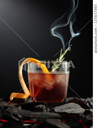 Old-fashioned cocktail with a burning twig of rosemary. Old-fashioned cocktail with a burning twig of rosemary. 135637065