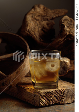 Whiskey with ice on a old wooden board. 135637085