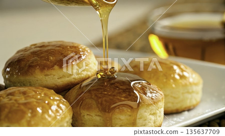 Delicious baked goods with syrup served on a white plate in a cozy kitchen setting Delicious baked goods with syrup served on a white plate in a cozy kitchen setting 135637709