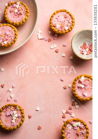 Valentine's day pink background. Pink mini tarts with heart shaped sprinkles. Top view, copy space 135638281