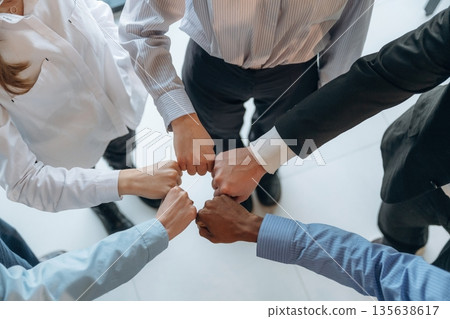 Fists to fists gesture. Top view of hands of business people that are celebrating success 135638617