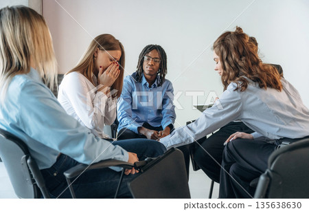 Woman is crying. People are in group psychological support room together 135638630