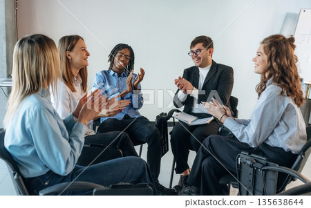Applauding together. People are in group psychological support room 135638644