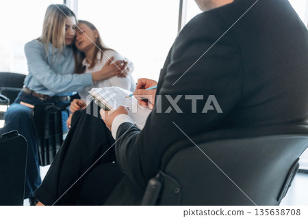 Depression, woman is crying. People are in group psychological support room together 135638708