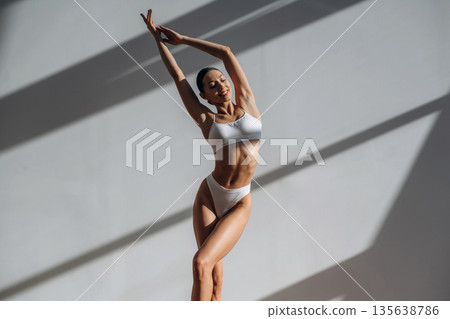 In sportive underwear. Beautiful young woman with slim body type is indoors 135638786
