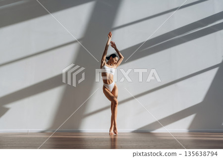 Daylight goes into the room. Beautiful young woman with slim body type is indoors Daylight goes into the room. Beautiful young woman with slim body type is indoors 135638794