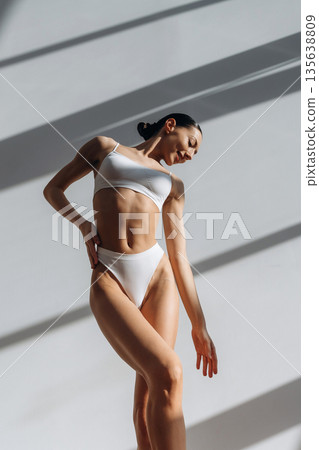 Showing slim body type. Beautiful young woman is indoors Showing slim body type. Beautiful young woman is indoors 135638809