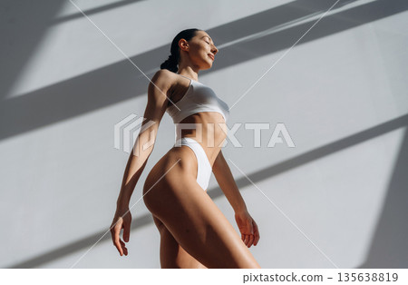 View from below. Beautiful young woman with slim body type is indoors 135638819