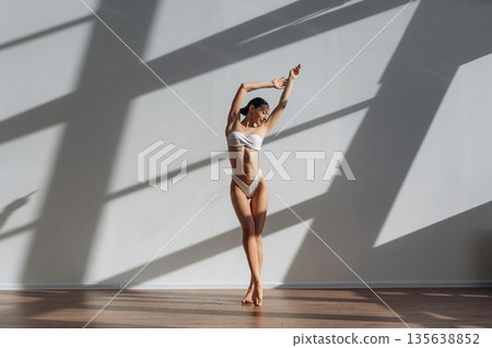 White clothes, bikini. Beautiful young woman with slim body type is indoors White clothes, bikini. Beautiful young woman with slim body type is indoors 135638852