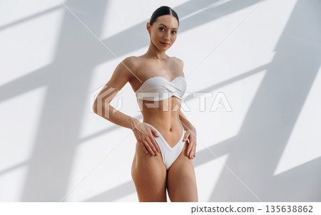 Just relaxing, standing and posing. Beautiful young woman with slim body type is indoors 135638862
