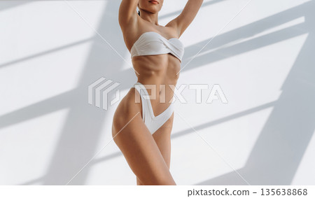 New bikini, standing and showing. Close up view of woman with slim body type indoors New bikini, standing and showing. Close up view of woman with slim body type indoors 135638868