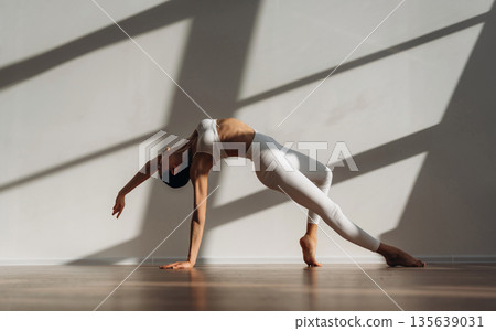 Physical activity, yoga exercises. Beautiful young woman with slim body type is indoors 135639031