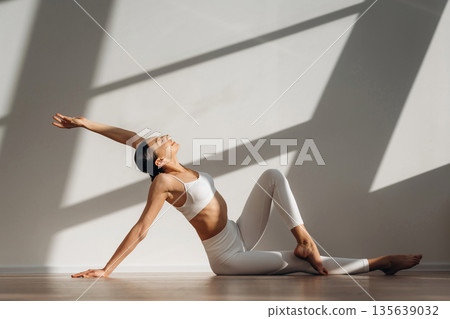 Physical activity, yoga exercises. Beautiful young woman with slim body type is indoors 135639032