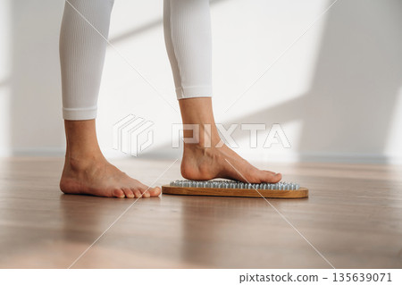 Ready to stand. Close up view of woman's legs that is standing on nails Ready to stand. Close up view of woman's legs that is standing on nails 135639071