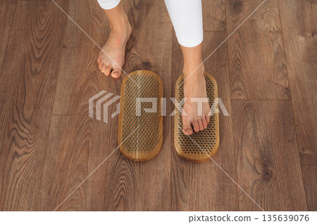 Close up view of woman's legs that is standing on nails Close up view of woman's legs that is standing on nails 135639076