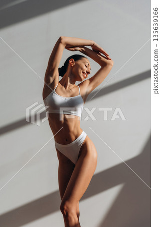 Bright sunlight. Pretty young woman with slim body type is indoors 135639166