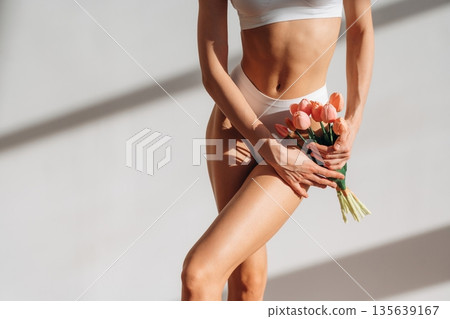 Gift of flowers, holding in hands. Close up view of woman with slim body type indoors 135639167